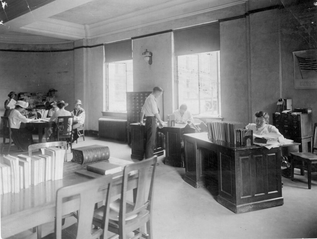  A photograph of patrons and staff in the Evansville Public Library when it was housed in the Coliseum in 1920. Ethel McCollough, the Library's first director, is on the right.